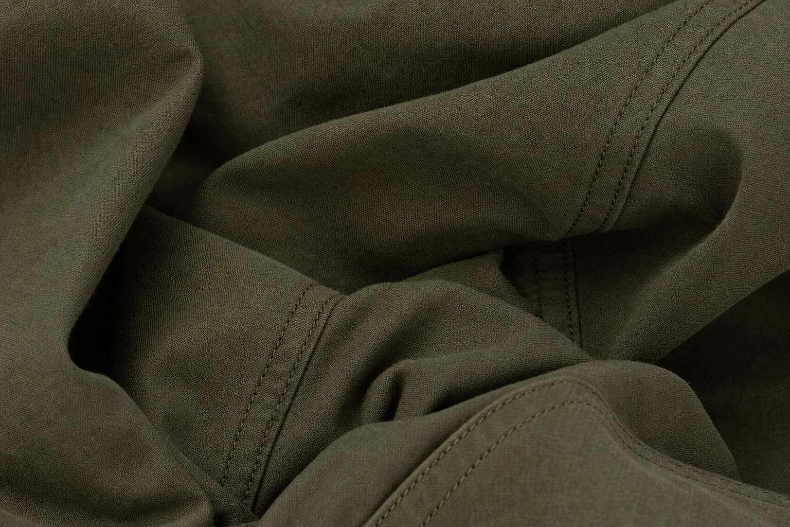 Close-up of olive cotton fabric with visible seams